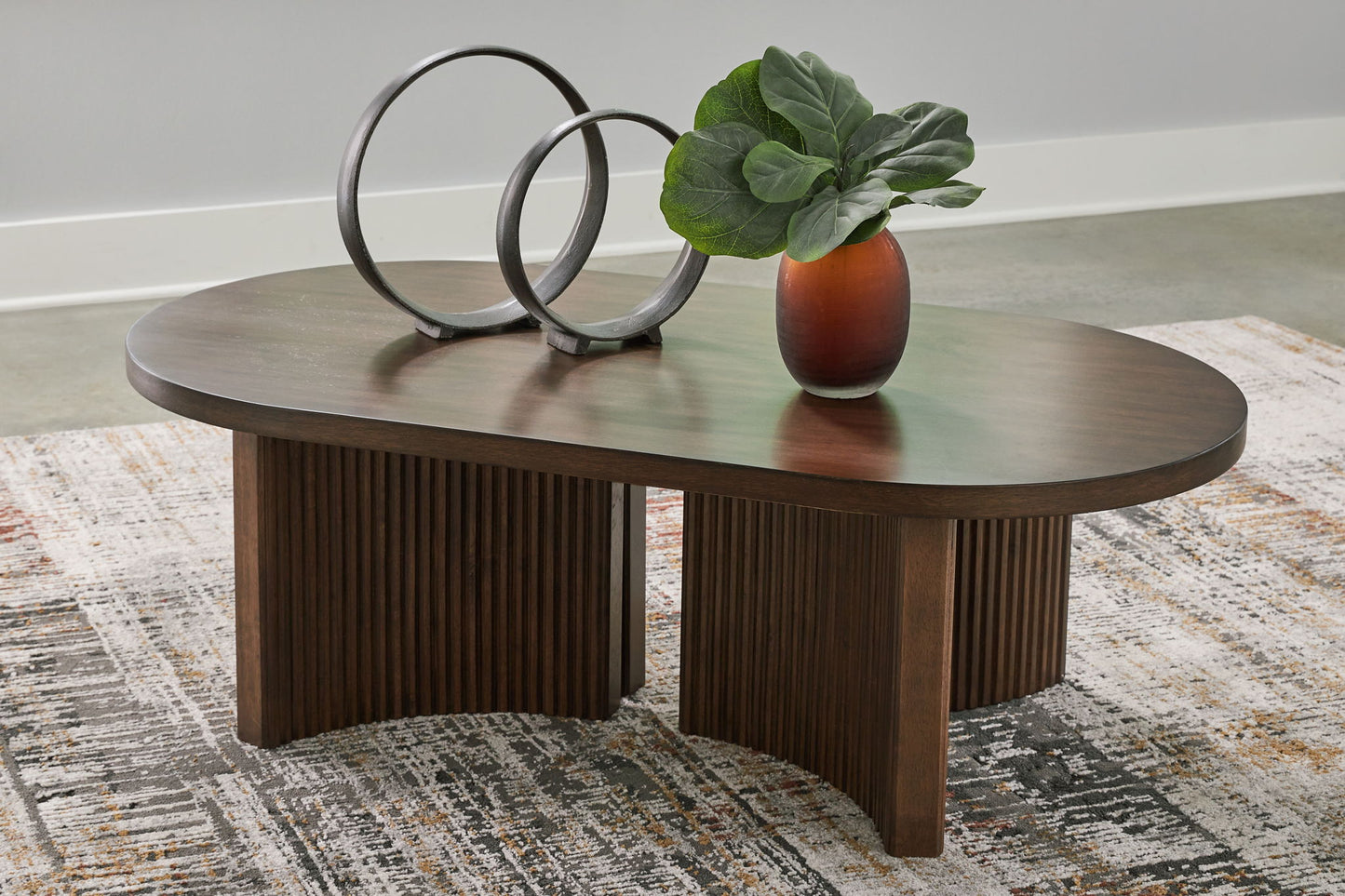 Korestone - Dark Brown - Oval Cocktail Table - Hornell Furniture Outlet